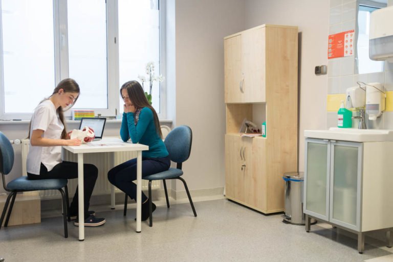 Fizjoterapeuta tłumaczy pracę dna miednicy dla pacjenta